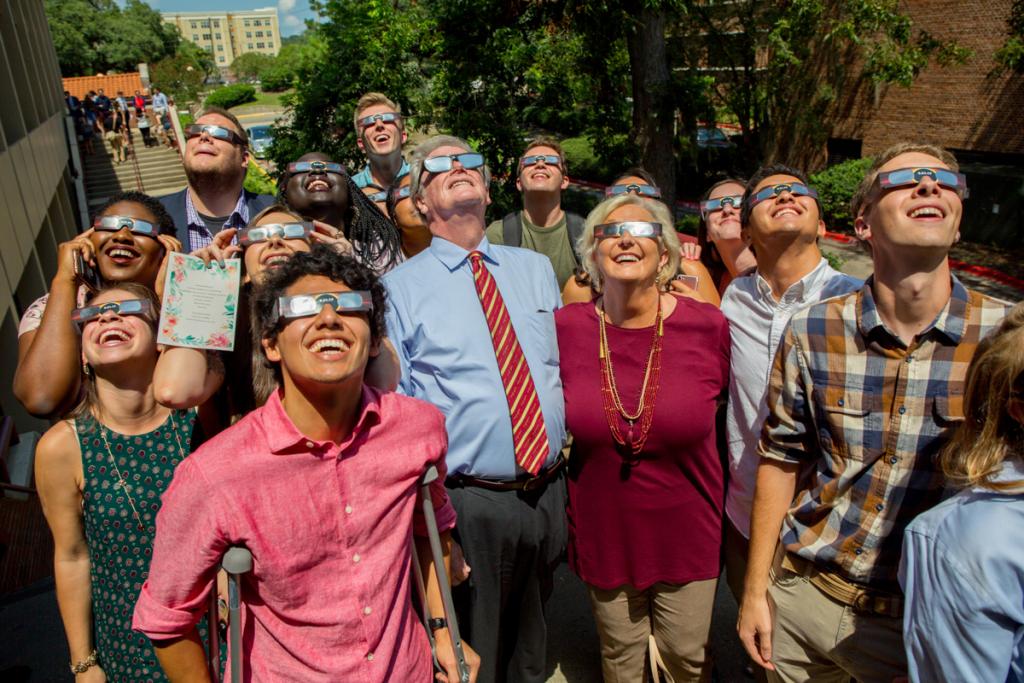 President John Thrasher and FSU First Lady Jean Thrasher watch the solar eclipse with students at the FSU Union Green Aug. 21, 2017. (FSU Photography Services)
