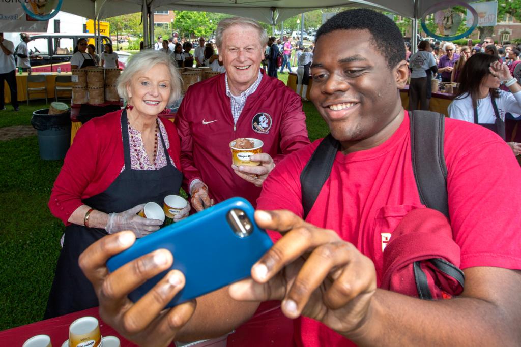 President John Thrasher and FSU First Lady Jean Thrasher take a selfie with a student during the President's Ice Cream Social on Landis Green April 12, 2018. (FSU Photography Services)