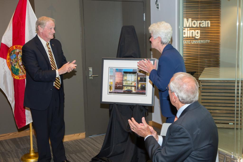 President John Thrasher presents Jan Moran with a framed portrait of the Jim Moran Building during the building's dedication April 18, 2018. (FSU Photography Services)